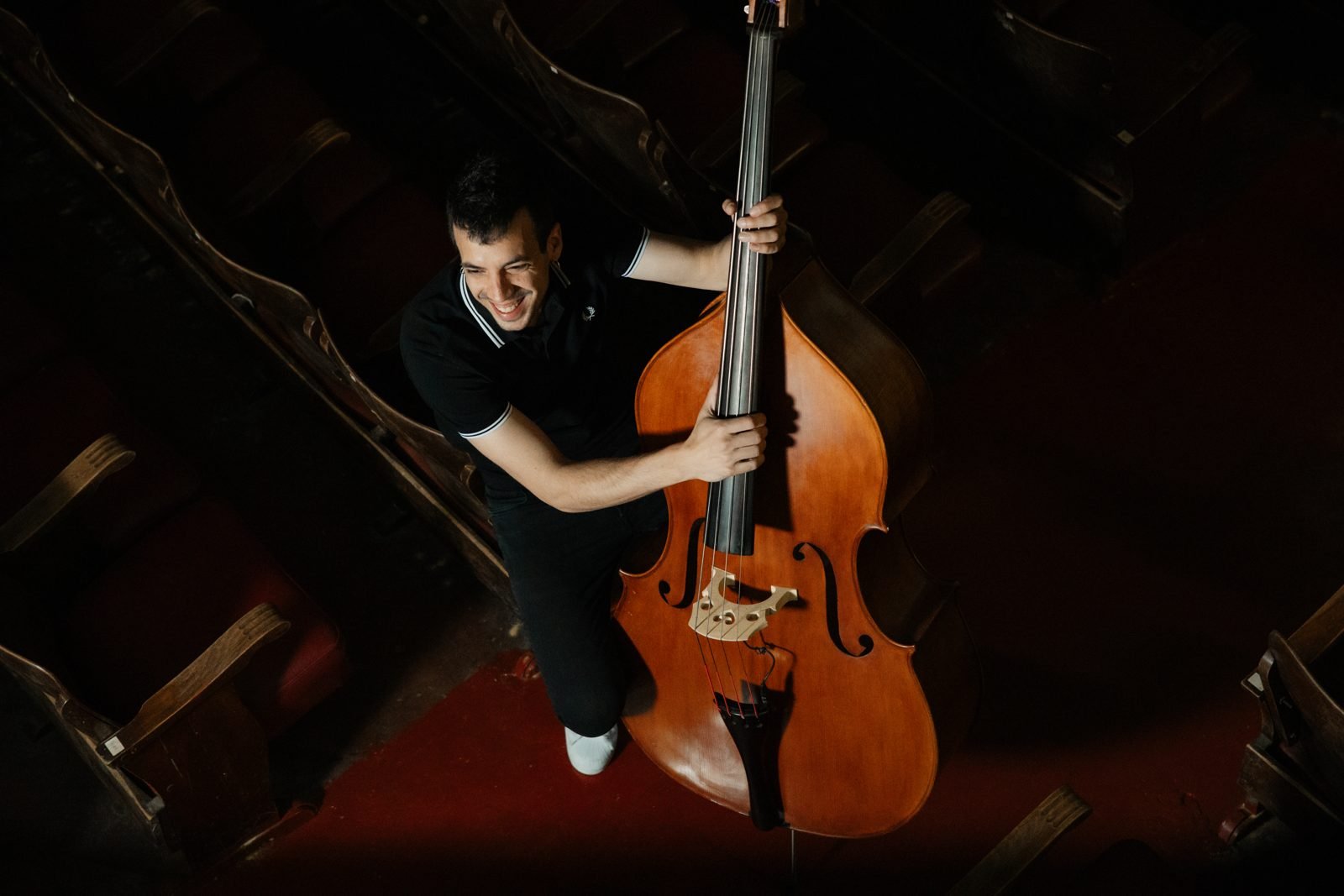 Músic somrient amb el contrabaix, vist des de dalt
