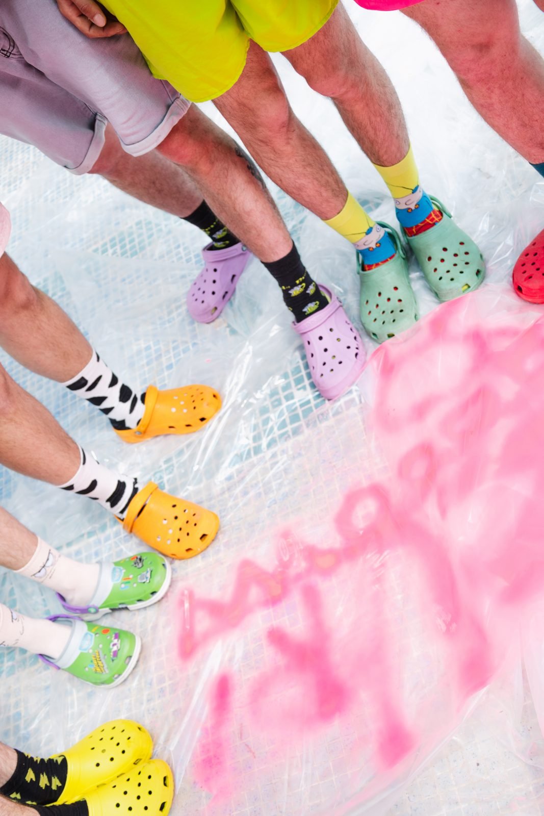 Detall de peus amb mitjons i Crocs de colors