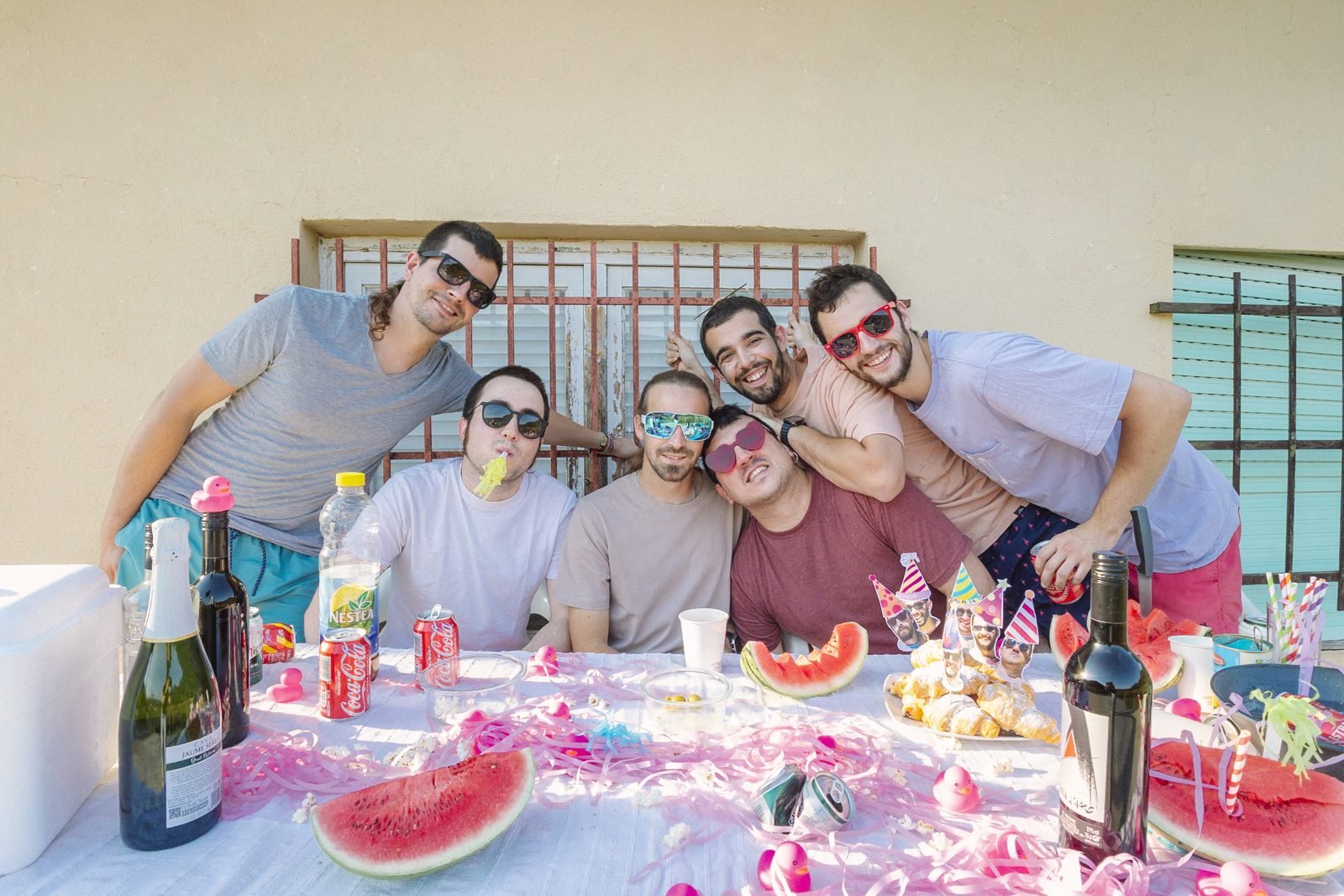 Sessió promocional d'un grup de música brindant al voltant d'una taula de festa