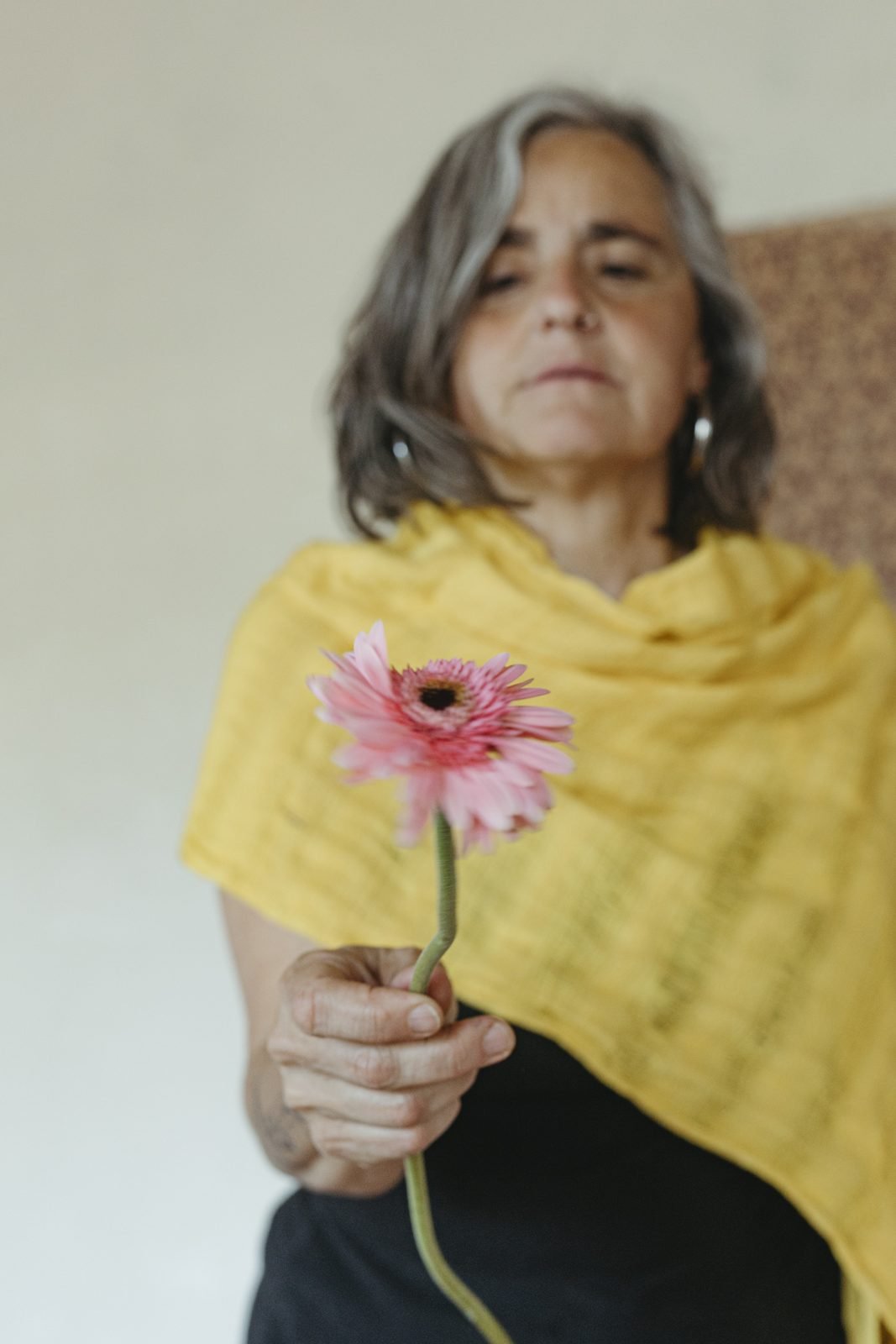 Una dona sostenint una gerbera rosa