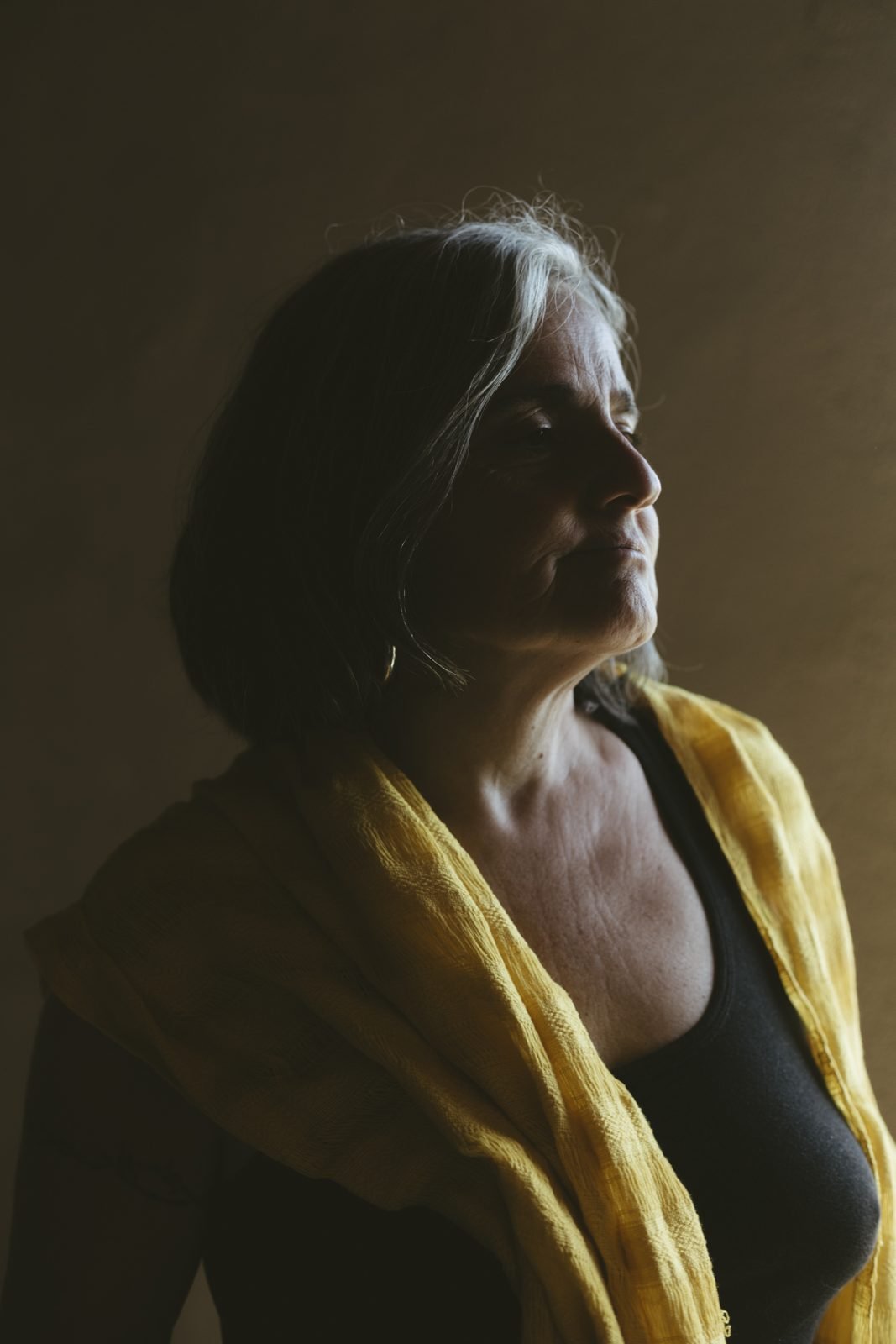 Retrat en penombra d'una dona amb xal groc