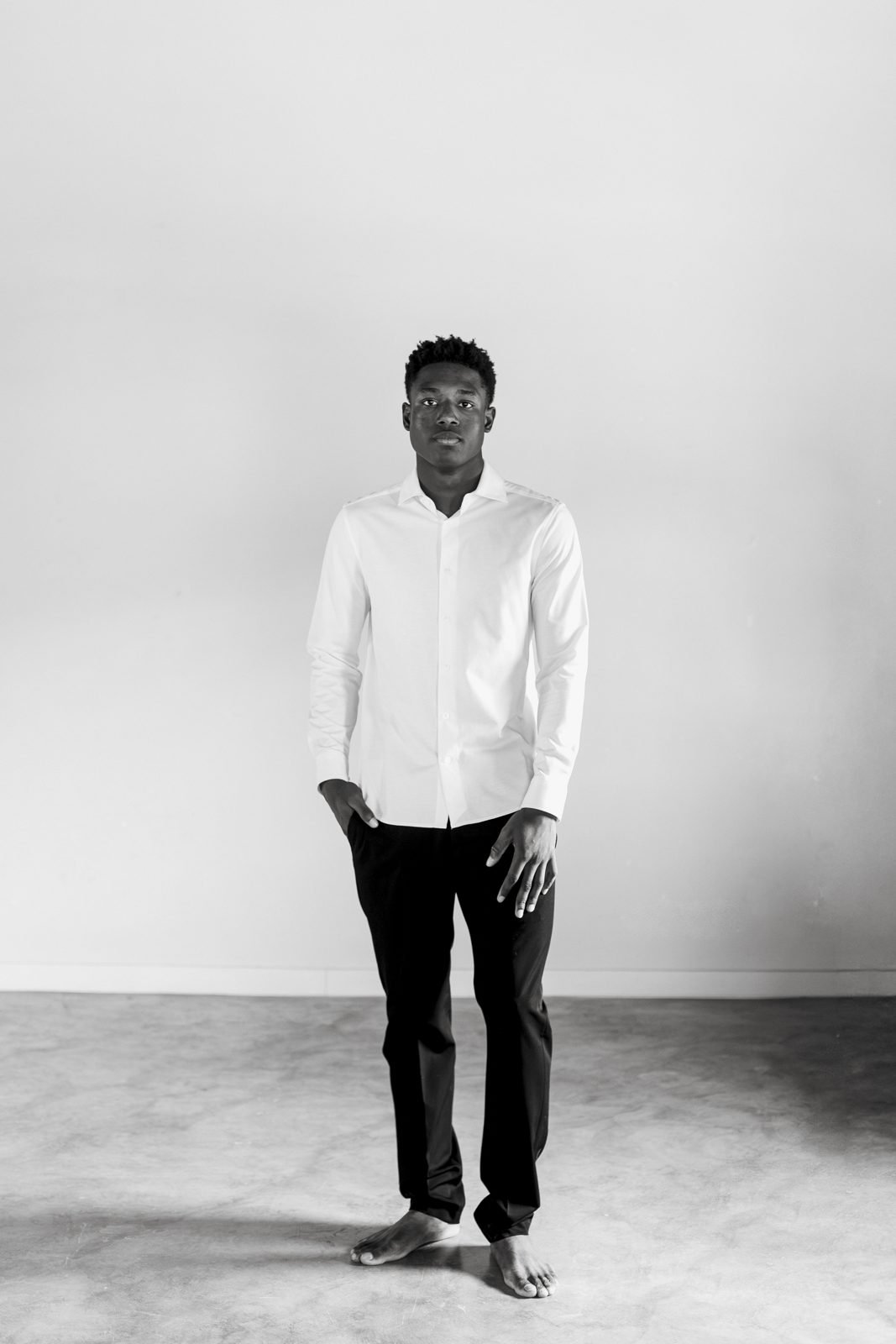 Retrat editorial d'un noi amb camisa blanca, en blanc i negre